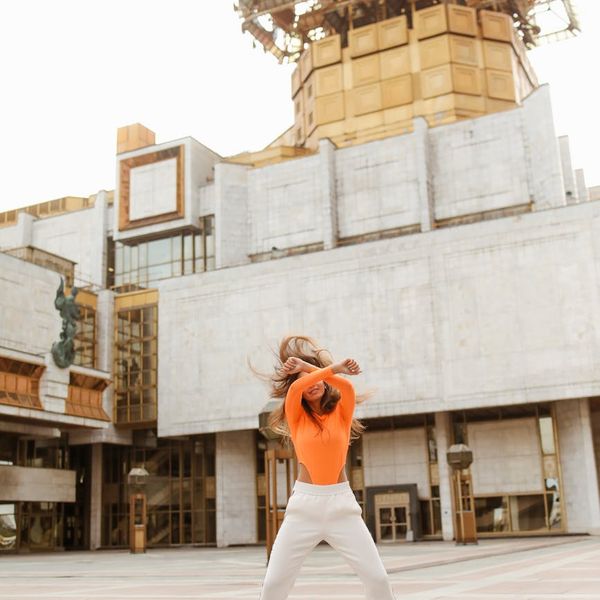 Person feeling energetic and stretching in a bright, open space.